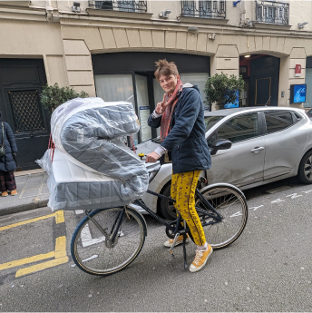 Paul transportant un matelas sur son vélo à Paris